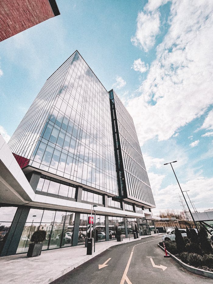 our-story Contemporary glass office tower reflecting the sky, showcasing modern architectural design.