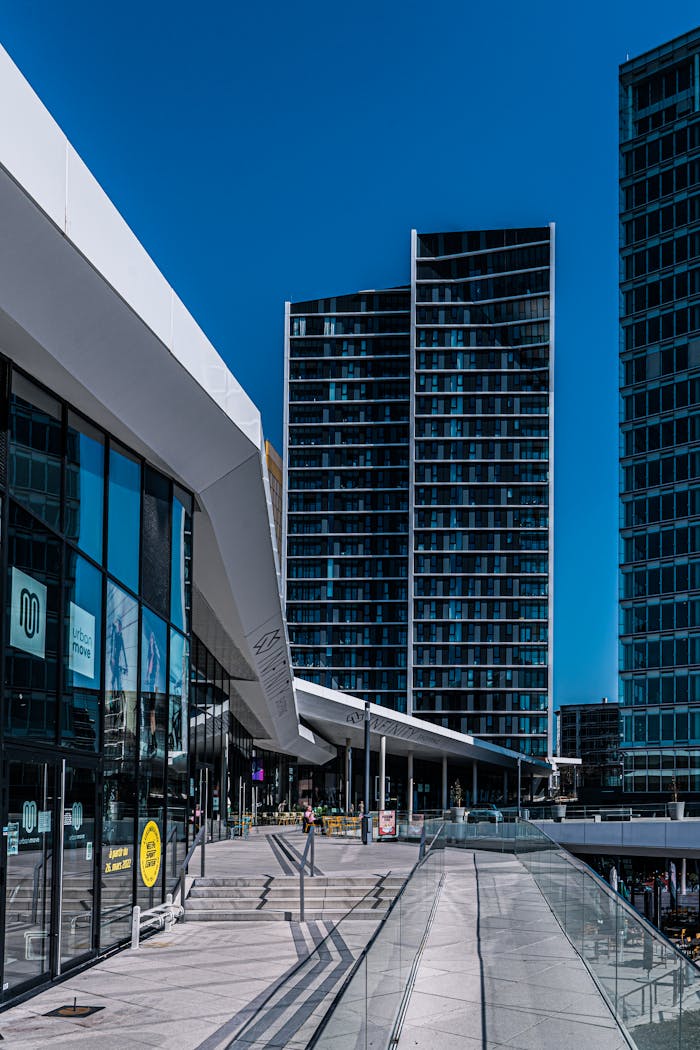who-we-are Contemporary urban architecture in Luxembourg with sleek glass facades and blue sky.